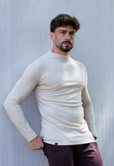 Camiseta slim masculina manga longa gola média na cor bege, vista frontal, modelo masculino com mão na cintura, peça de malha canelada de moda masculina CW Store